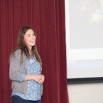 Female presenter next to slide